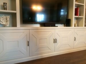 gray lacquered entertainment cabinet with cnc'ed doors